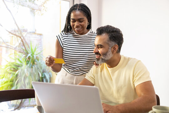 Cheerful couple shopping online at home together