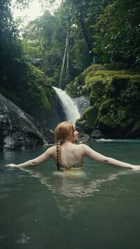 Young woman hiking in a tropical rainforest jungle 