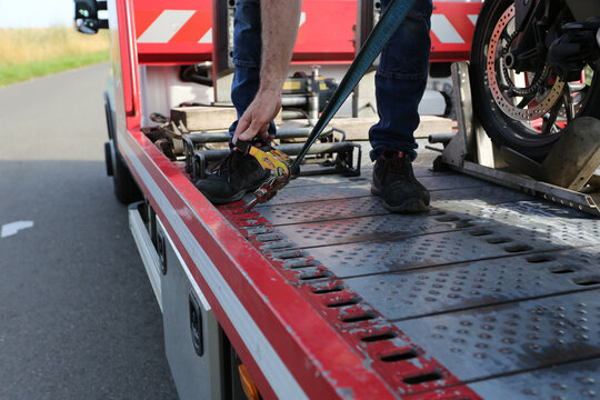 D&eacute;panneur en train d'attacher une moto sur la d&eacute;panneuse