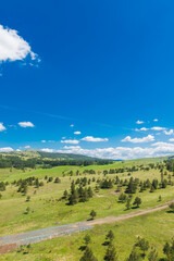 green hills against blue sky with white clouds in summer on a sunny day