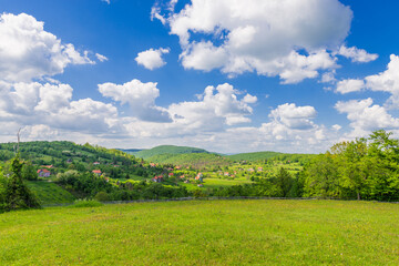 Houses among green hills in the distance