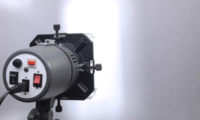 Professional studio light with curtains on a tripod on a gray background