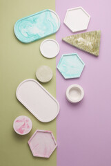 Plaster geometric shapes, trays on purple green background. Top view