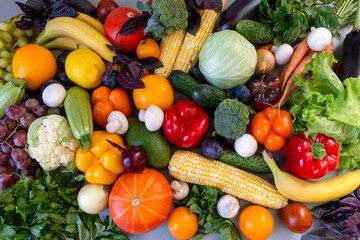 Assortment of Fresh Fruits and Vegetables. A colorful assortment of fresh fruits and vegetables, including oranges, bananas, peppers, tomatoes, grapes, and leafy greens.