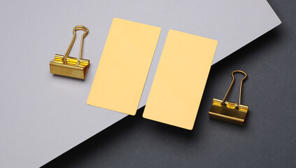 Gold business cards and binders on a gray background