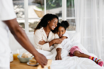 Mother and daughter enjoying a cozy morning in bed together