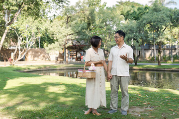 Senior Couple Enjoying a Relaxing Day in the Park Holding Hands and Smiling