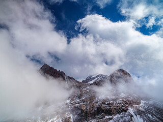 Impregnable cliffs peek out of the clouds. Stony cliffs high in the mountains. Talgar Pass