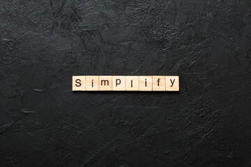 simplify word written on wood block. simplify text on table, concept