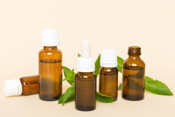 Natural Mint Essential Oil in a Glass Bottle. organic cosmetics with herbal extracts of mint on colored background