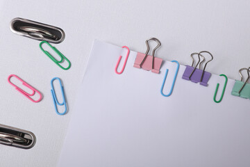 White blank sheets of paper with colored paper clips and binders