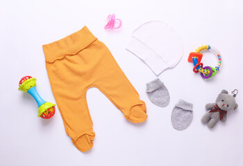 Set of newborn clothes, accessories and toys on a white background. Flat lay. Top view