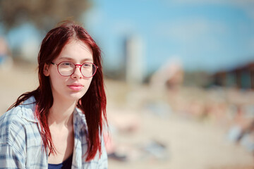 Young girl on the beach in summer looking at the distance. Generation Z, sixteen-year-olds, plans for the future, youth.