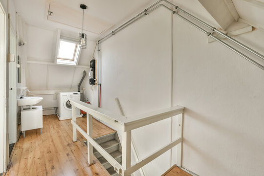 Compact attic laundry room with skylight and wooden floors