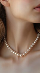 A graceful neck showcases a beautiful string of pearls, enhancing elegance and timeless style in natural lighting