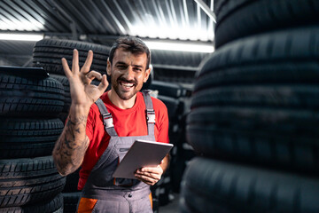 Employee organizing tire inventory in warehouse.