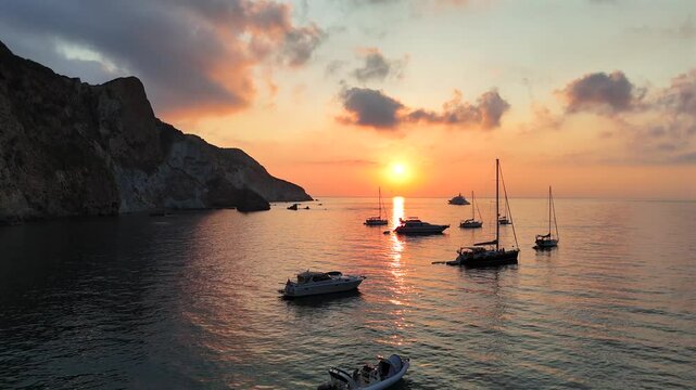 Risveglio all'alba nella baia dell'Arco Naturale dell'isola di Ponza, Italia, Mar Tirreno, Mediterraneo.
Le barche ancorate nella baia pi&ugrave; suggestiva di Italia in una mattina d'estate col sole giallo.