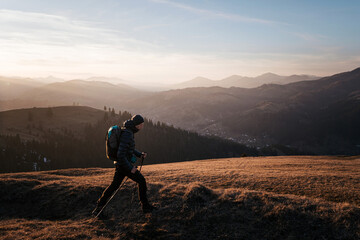 Fototapeta premium Solo Hiker Walking at Sunset on Mountain Ridge