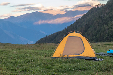 Yellow tent on the background of the mountains