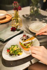 a person eating a healthy avocado toast in an alfresco dining retaurant