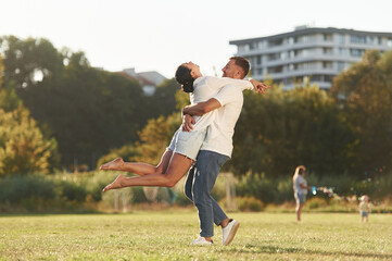 Obraz premium Closeness, embracing. Mother and father are with son outdoors on the field