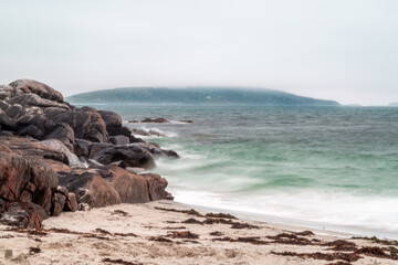 Evening view from a beach in south Uist, Image shows long exposure photo showing a small beach on a cloudy day as a storm approaches