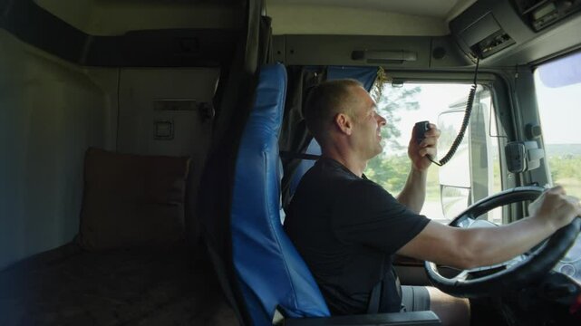 A long-distance driver takes a walkie-talkie in his hands to warn his colleagues about problems on the road. High quality 4k footage