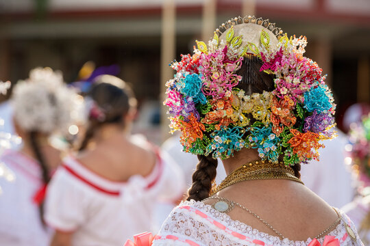 Young woman wearing a beautiful and colorful national pollera dress with elaborate beaded tembleques and gold jewelry, participating in a cultural event, Panama - stock photo