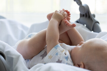 Newborn baby exploring his body. Selective focus.
