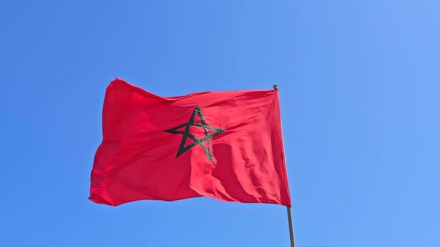 view of a Moroccan Flag waiving against blue sky - Kingdom of Morocco flag waving 