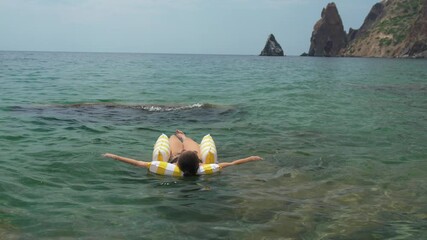Relaxing on a Yellow Striped Float in the Ocean