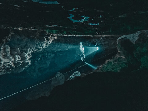 Scuba divers light up the cavern as they enter Ginnie Ballroom, Ginnie Springs, Florida