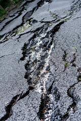 Very destroyed road asphalt surface close up after mudflow