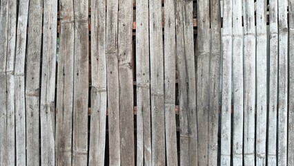 Thin layers of bamboo arranged vertically, forming a pattern of parallel lines. The color of the bamboo layers varies with a rough surface texture and clearly visible fibers