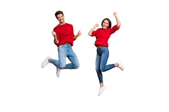 Full length photo of cheerful woman and man jump raise fists scream yes celebrate victory wear red sweater denim jeans isolated over yellow background