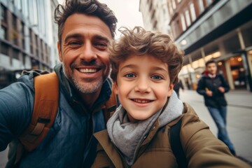 Fototapeta premium Father and son talking selfie in the city