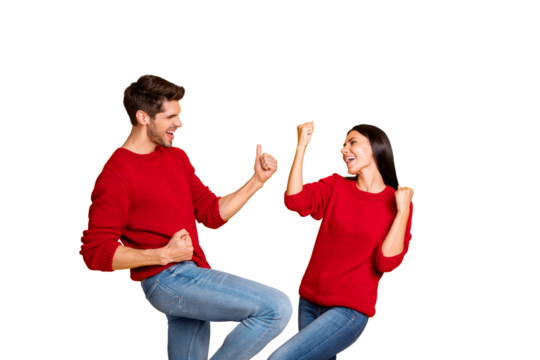 Portrait of delighted two married people raise fists scream yeah celebrate victory wear red sweater denim jeans isolated over yellow background