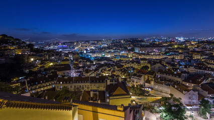 Lisbon panorama after sunset aerial view of city centre with red roofs at autumn day to night timelapse, Portugal