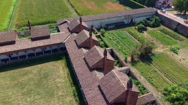 Certosa di Pavia seen from an aerial view, Italian wonders and art, historical monumental complex that includes a monastery and a sanctuary. green court and a church. Pavia, Italy
