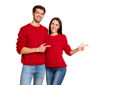 Portrait of charming spouses point at copy space recommend ads wear red pullover sweater denim jeans isolated over yellow background