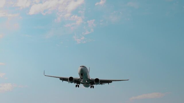 White passenger airplane gains altitude after taking off from the airport, soaring into a cloudy sky. The scene captures the excitement of air travel and the beauty of flight