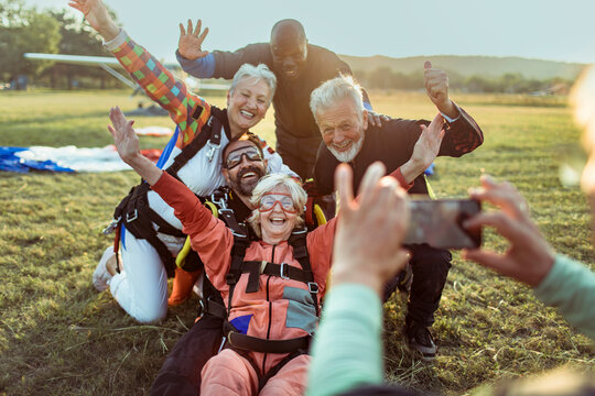 Group of senior skydivers taking a selfie after landing