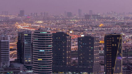 Dubai's business bay towers at evening aerial day to night timelapse.