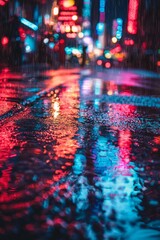 A close-up shot of neon lights reflecting in rain puddles on a dark city street at night. 