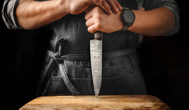 Chief man holding knife at kitchen