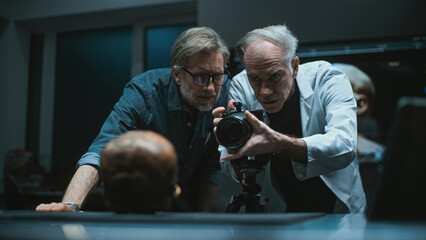 Modern archaeological laboratory: Two archaeologists set up professional camera to photograph...