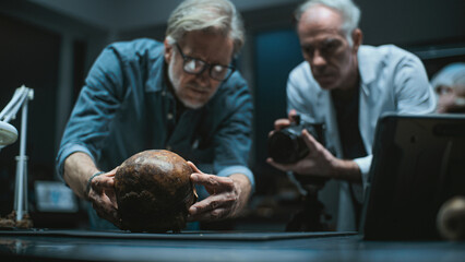 Modern archaeological laboratory: Two archaeologists set up professional camera to photograph...