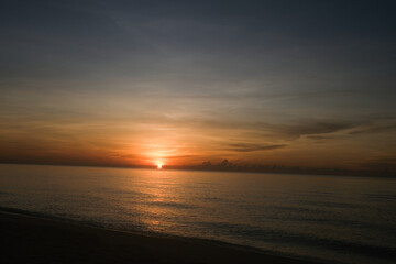 The sun rises at the sea in the morning.