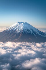 Fototapeta premium A distant snow-capped volcano rising above the clouds