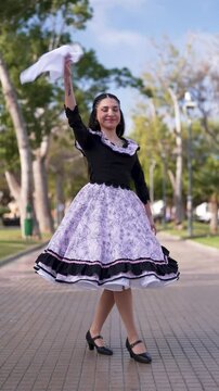 mujer chilena vestida con traje tradicional bailando cueca y posando